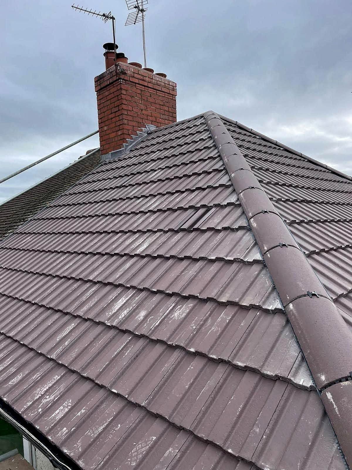 Completed tiled re-roof with new ridge tiles and a brick chimney