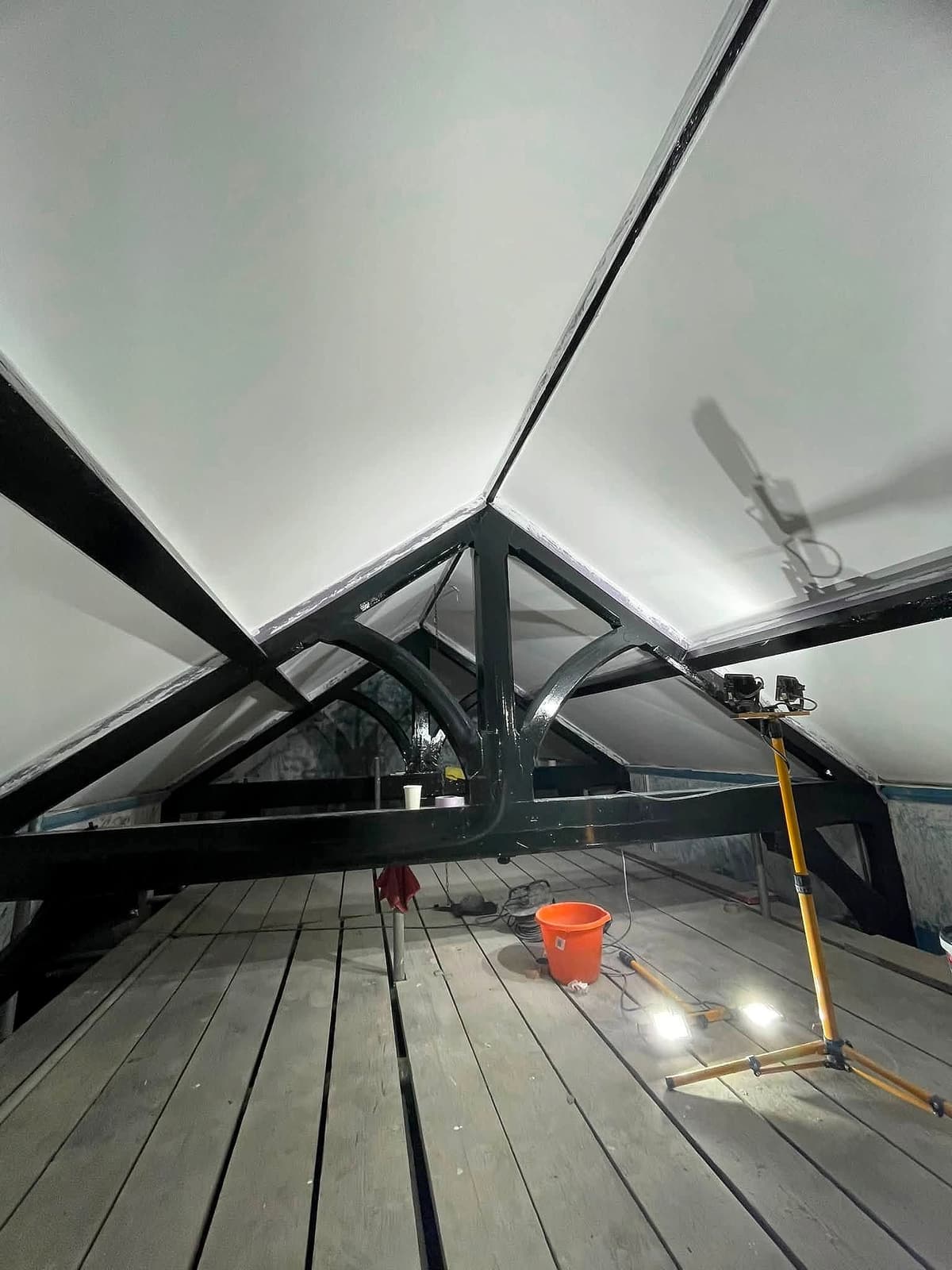 Vaulted interior ceiling with dark exposed trusses and a new timber floor