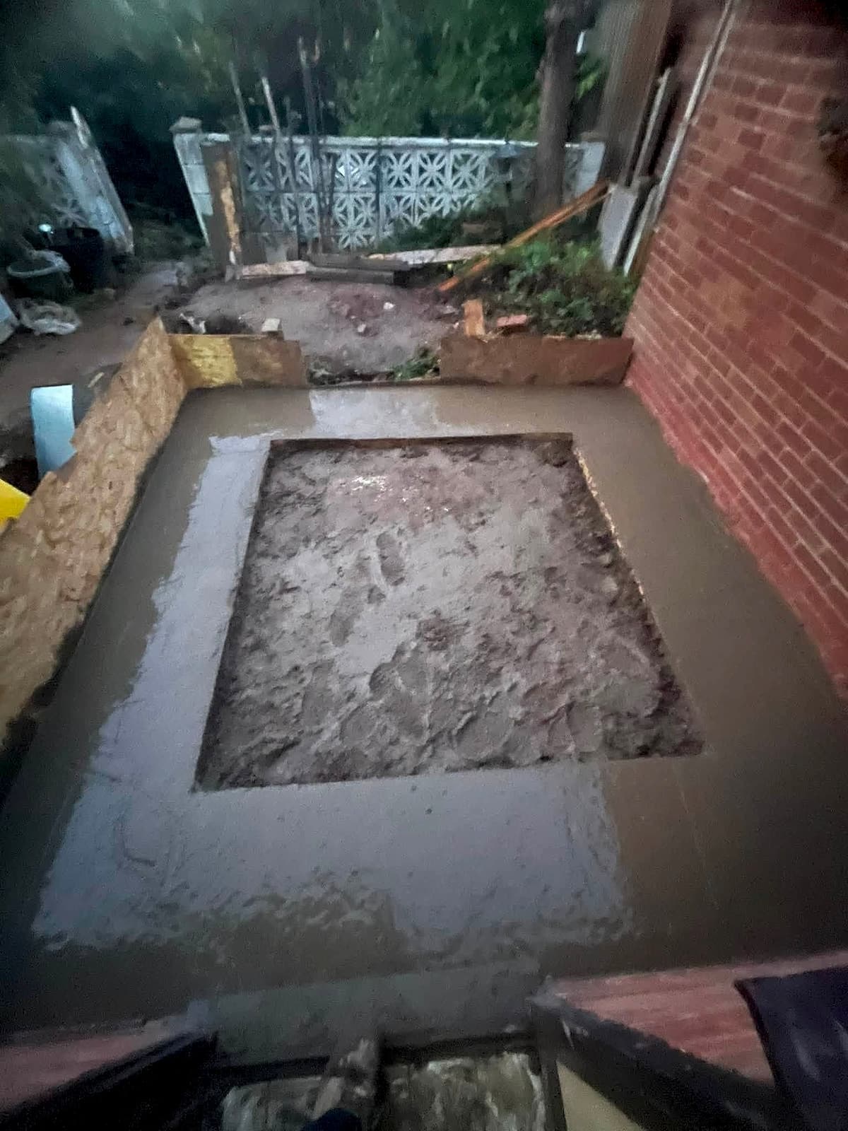 Freshly poured concrete base inside timber shuttering