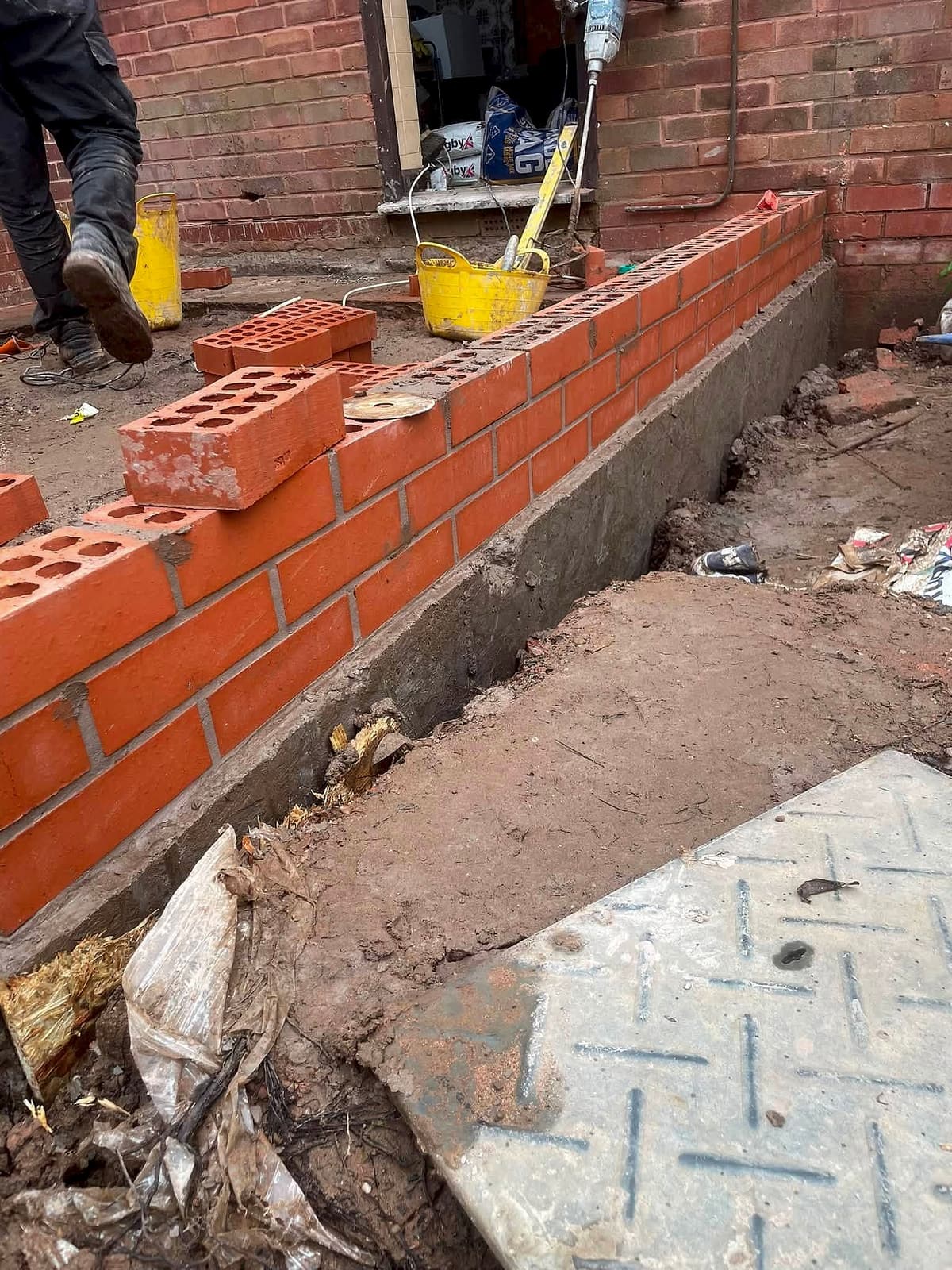 New brick wall being built on a concrete footing