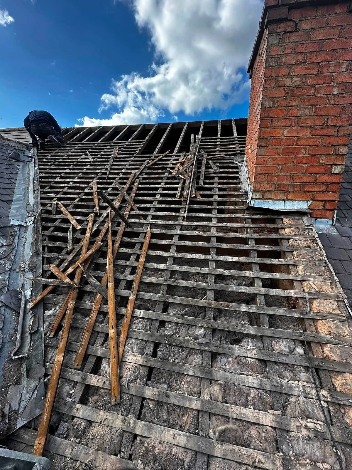 Old slates stripped from a roof, showing broken battens