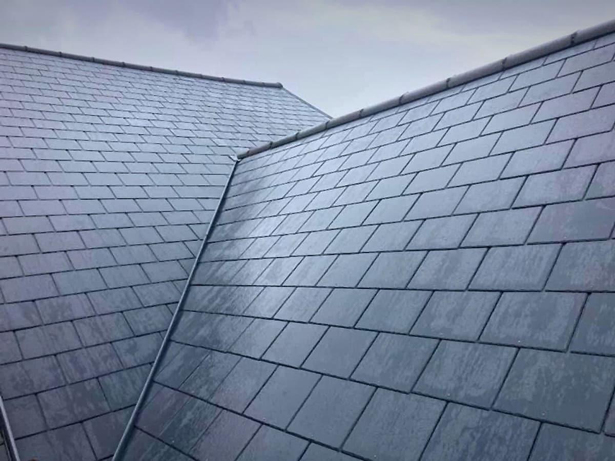 Finished slate roof with new slates meeting at a valley