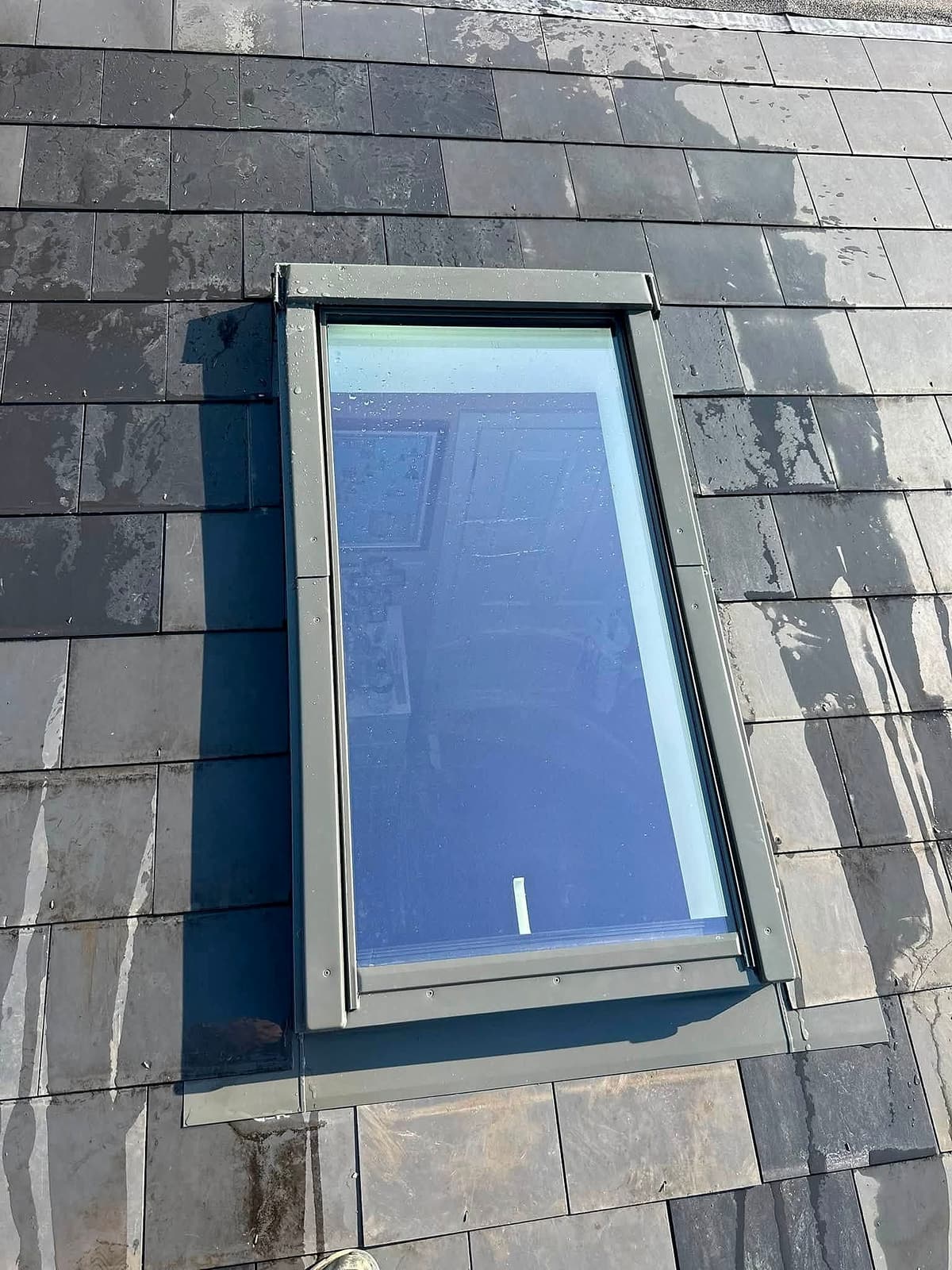Finished roof window set into a slate roof